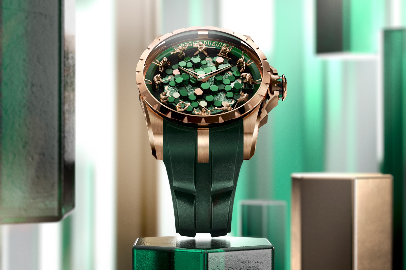 Watches are statement accessories and few brands have taken that concept to the extremes that Roger Dubuis has. With the Knights of the Round Table collection, you don’t just get a timepiece, you get an entire tableau of sculpted figures inspired by Arthurian legend. The newest addition to the collection is the Knights Of The Round Table The Metamorph Merlin, the third and final edition in a trilogy dedicated to Arthur’s faithful wizard and advisor.
Jumping straight to the dial, The Metamorph Merlin features a multi-layer, multi-material display consisting of hexagonal columns inspired by the natural basalt formations of the Giant’s Causeway in Northern Ireland. The original 2024 Omniscient Merlin featured black columns, the 2025 Enchanter Merlin was white and the 2026 Metamorph Merlin is green. The colour is designed to evoke images of the great magical forest of the old stories, where the Lady of the Lake dwells and where Merlin shapeshifts into his various guises (it’s this talent for shapeshifting that gives the watch its Metamorph name).
The columns of the dial are made from one of four materials: polished glass with CVD coating, transparent glass, sparkling Crystalium or pink gold. Pink gold is also used for the central hour and minute hands as well as the peripheral sculptures of the twelve knights who serve as the hour markers. Each of the knights is sculpted in exacting detail with poses that range from ready to strike, to kneeling or being on guard.
Housing the tableau is a 45mm diameter case made from pink gold. For the first time in the collection’s history, it features engraved images along the caseband and sides of the lugs. Along the wide edge on the 9 o’clock side of the watch, it depicts a handful of knights recreating some of the poses from on the dial. Meanwhile, flanking the crown at 3 o’clock are images of Merlin himself and a white stag – one of the creatures Merlin can transform into. Above the edge of the case is a sapphire window that lets you view the dial from multiple angles, and above that sits the pink gold bezel.
Powering the Roger Dubuis Knights Of The Round Table The Metamorph Merlin is the automatic calibre RD821. It has a 48-hour power reserve and operates at a 4 Hz frequency which are solid specs, but not really why the movement stands out. What makes it special is the flawless finishing and intricate, twisting architecture that’s visible through the exhibition caseback and which earn the watch the Poinçon de Genève. Around the edge of the caseback is an inscription celebrating the duty and charge of the Knights of the Round Table.
Roger Dubuis Excalibur The Metamorph Merlin