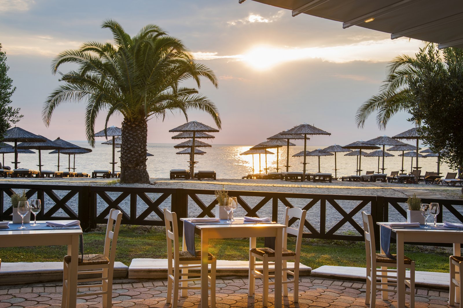 Tables at Cikado beach restaurant at sunset, Porto Carras Grand Resort